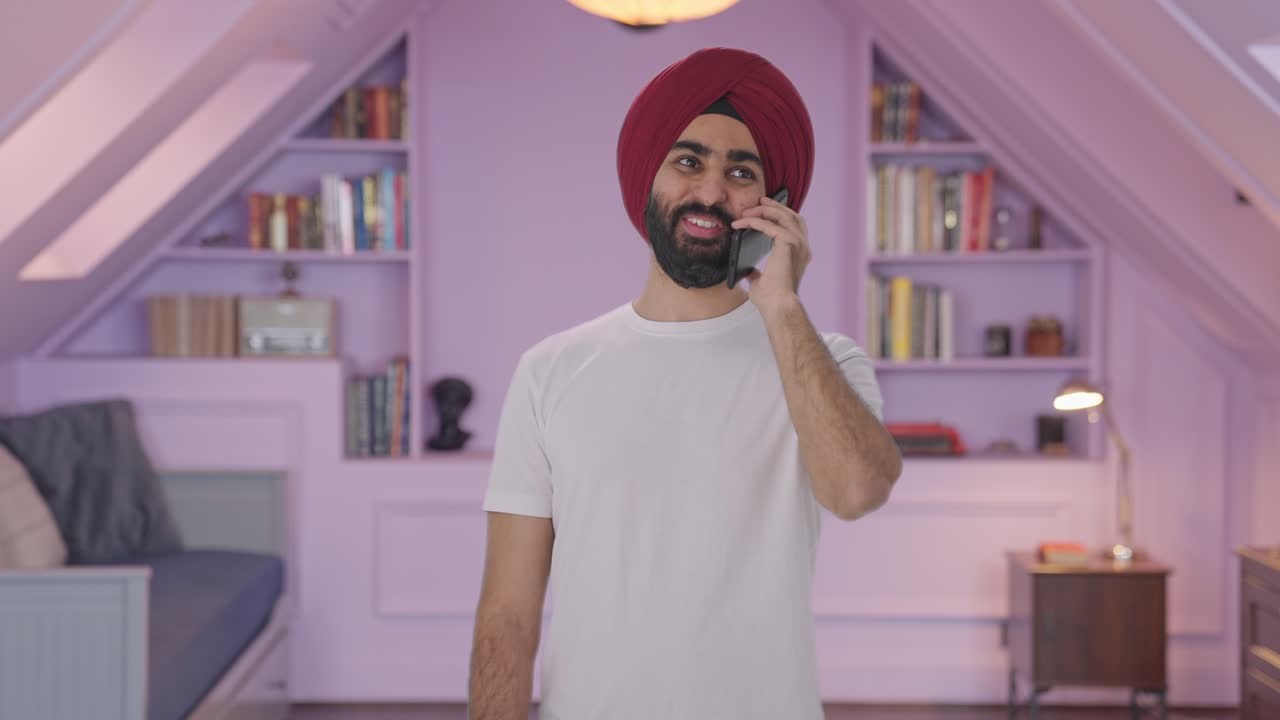 Uomo Sikh indiano felice che parla al telefono