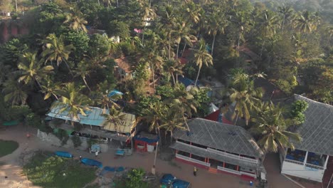 varkala beach shacks and buildings amidst the tropical coastline vegetation - aerial low angle panoramic survey shot