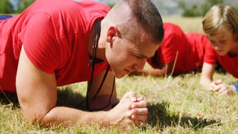 entrenador instruyendo a los niños mientras hacen ejercicio en el campamento de entrenamiento