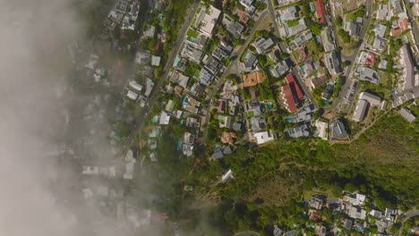 Top-down-panning-footage-of-luxurious-residences-in-urban-neighbourhood.-View-partly-covered-by-low-clouds-or-fog.-Cape-Town,-South-Africa