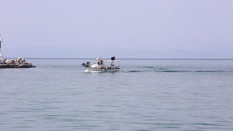 fishing boat is approaching the harbor, greece thessaloniki