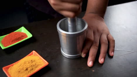 el chef muele el garam masala con mazo para preparar comida