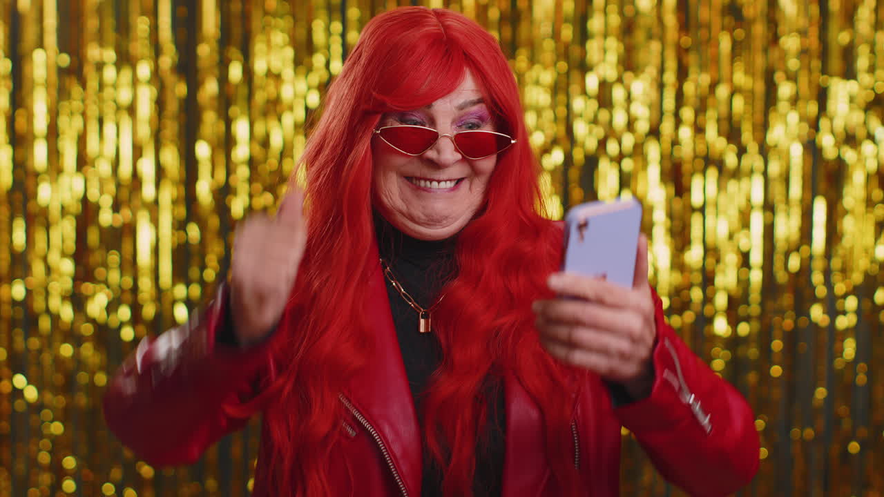 행복한 시니어 여성은 휴대전화를 사용합니다. 와우, 네, 위대한 큰 승리의 소식을 발견했습니다.