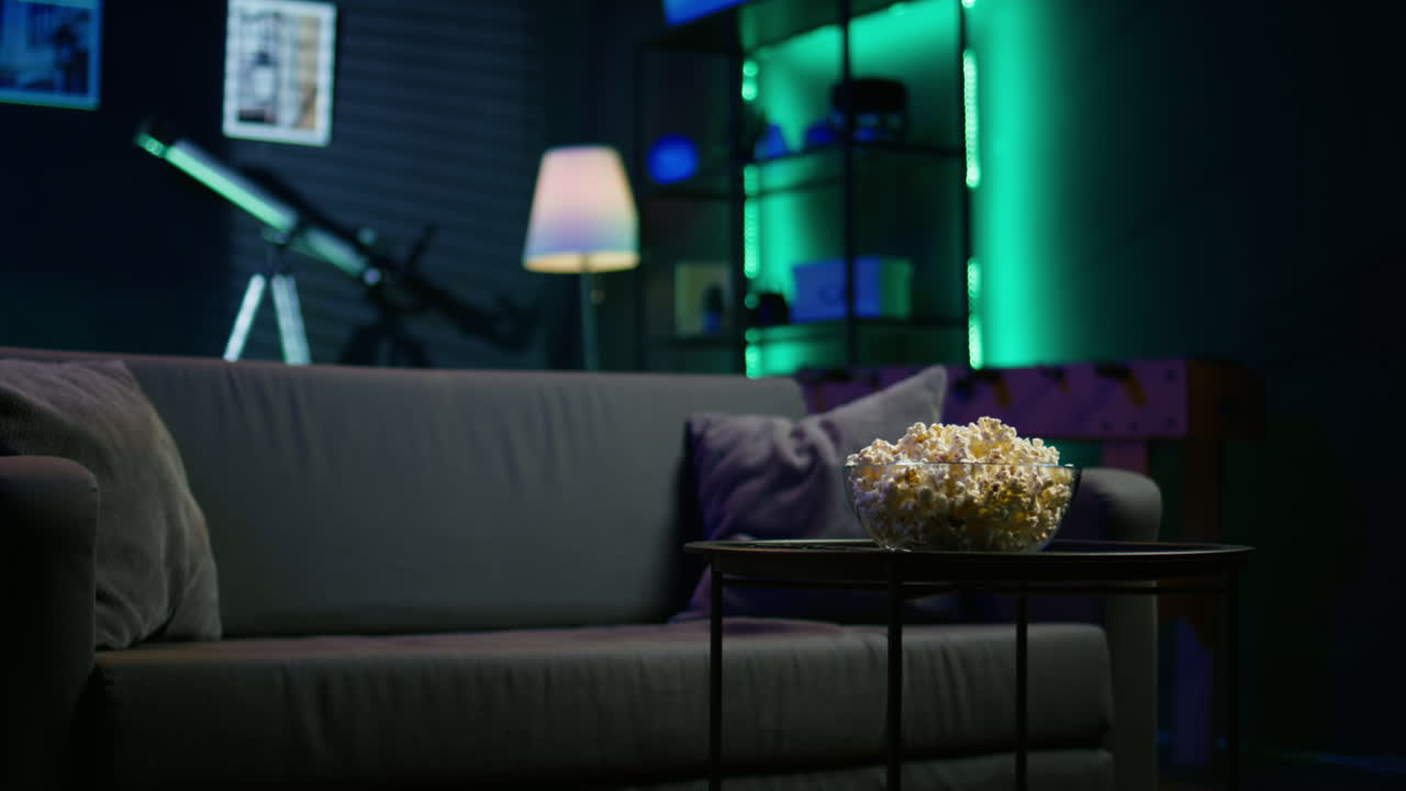 cuenco de palomitas de maíz en la mesa en la sala de estar, cerca de la toma de panorámica