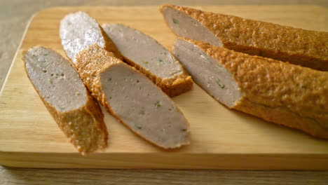 pastel de pescado chino frito o línea de bolas de pescado en tablero de madera