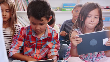 maestro y niños en una escuela primaria usando tabletas