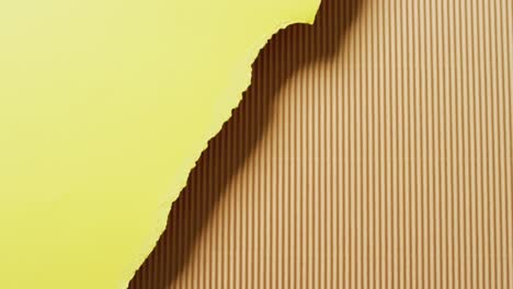 video of close up of torn pieces of yellow and brown striped paper background