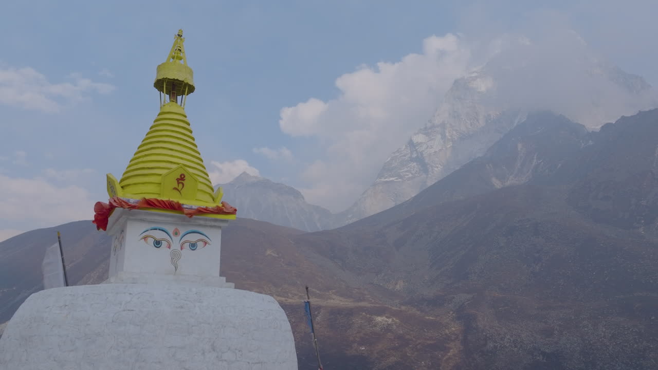Aerial view of Buddhist Stupa and pinnacle view at Dingboche (4400m) with hills, cloud-covered peaks, and global warming alert in the Everest region of Nepal, environmental protection Nepal