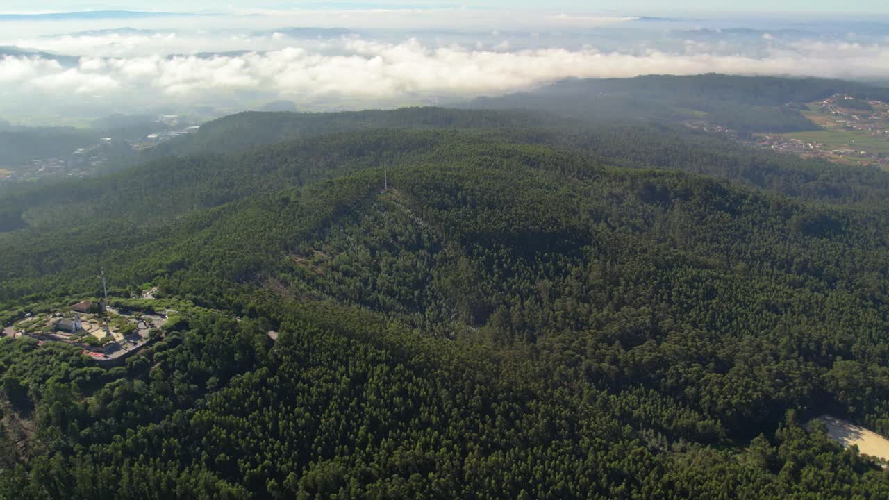 Vista aerea di un paesaggio montano nebbioso con foresta e torre delle comunicazioni