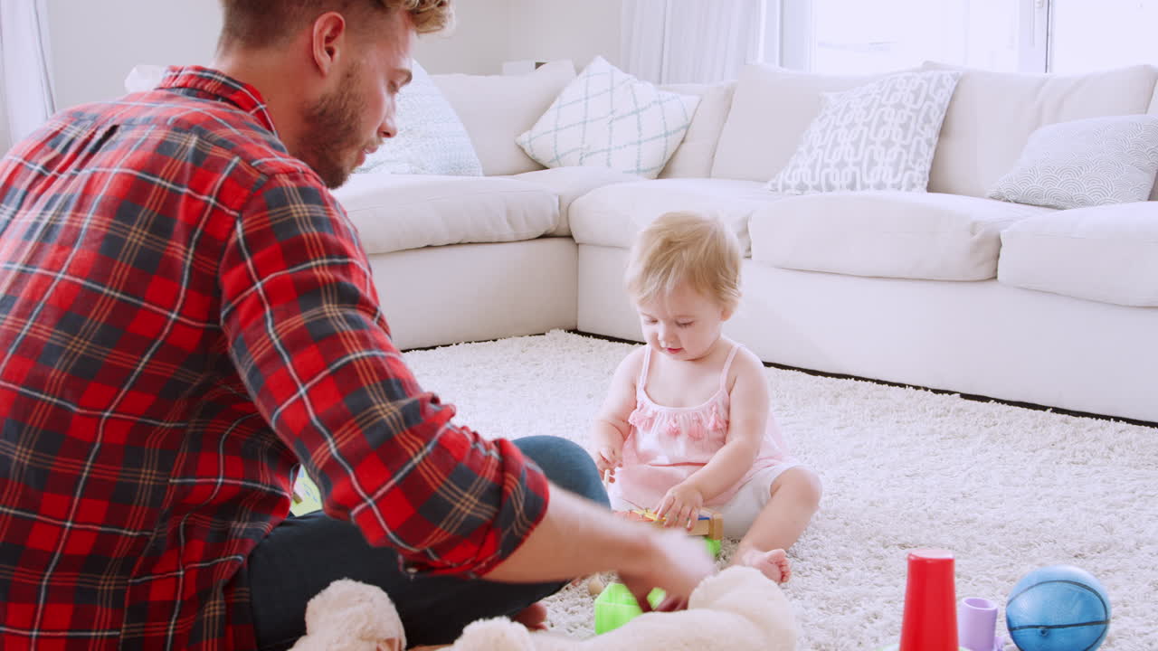 아빠와 어린 딸이 거실에서 악기를 연주하고 있습니다.