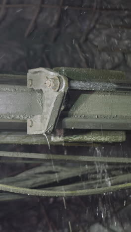 robot drill does rock drilling in mine spraying cold water. professional machinery equipment with pipes and coolant makes holes for explosives closeup