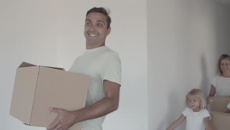 familia feliz con dos hijos que entran en un apartamento vacío