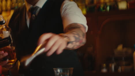 bartender preparing a cocktail with black label whiskey