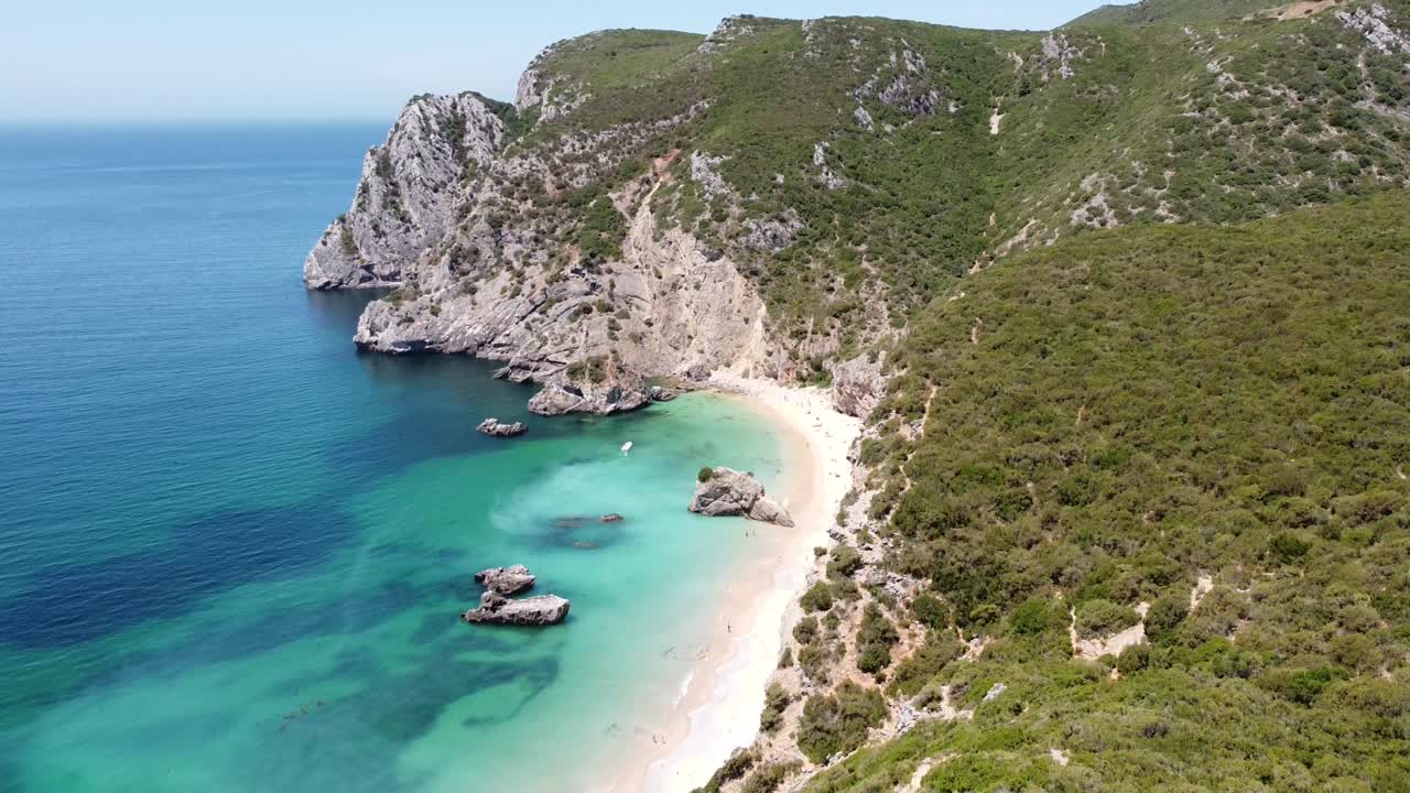 пляж praia ribeira do cavalo возле сезимбры, алентежу, португалия - вид с беспилотника на скалистое побережье, райский песчаный пляж и бирюзовое море