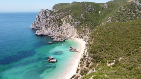 playa praia ribeira do cavalo cerca de sesimbra, alentejo, portugal - vista aérea de drones de la costa rocosa, playa de arena paradisíaca y mar turquesa