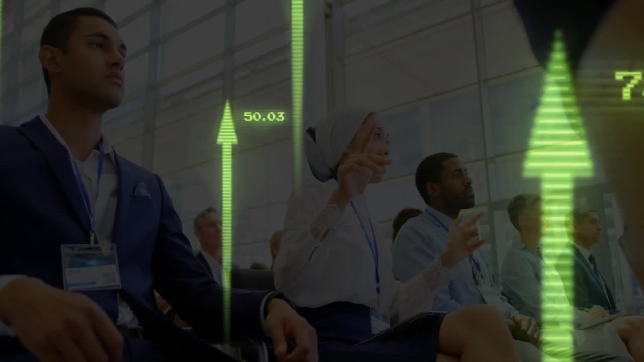 Conference attendees raising hands at business seminar, showing green arrows numeric data overlays