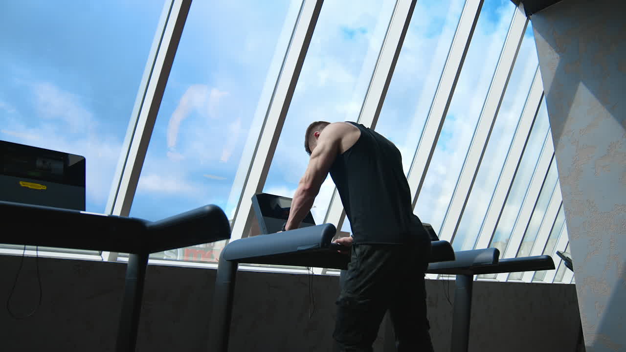 Fitness man running on treadmill. Young man running on the treadmill in the fitness studio