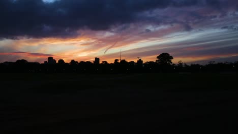 Clouds-move-above-the-silhouette-of-a-cityscape-in-a-stunning-sunset