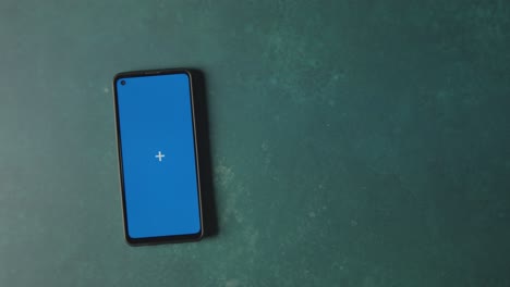 Overhead-Studio-Shot-Of-Gold-Coins-And-Blue-Screen-Mobile-Phone-To-Celebrate-St-Patricks-Day