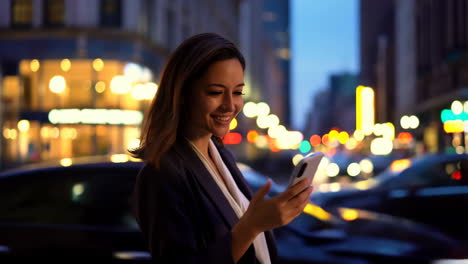 woman using smartphone on a busy city street at night