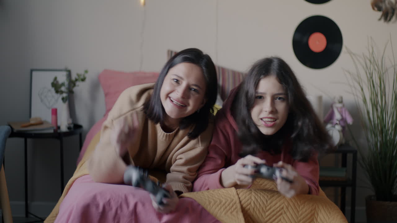 Two Teen Girls Gaming on a Bed