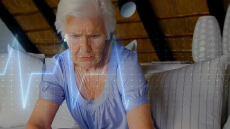 animation of cardiograph over senior caucasian woman at home