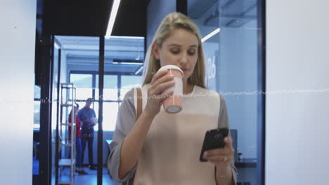 animación de procesamiento de datos sobre una mujer caucásica bebiendo café y usando un teléfono inteligente en la oficina.