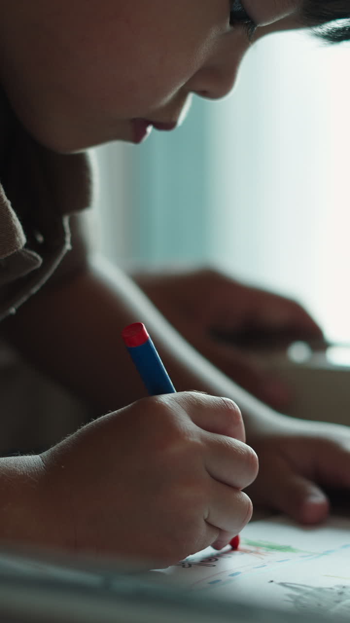 Bambino concentrato che disegna con un pastello