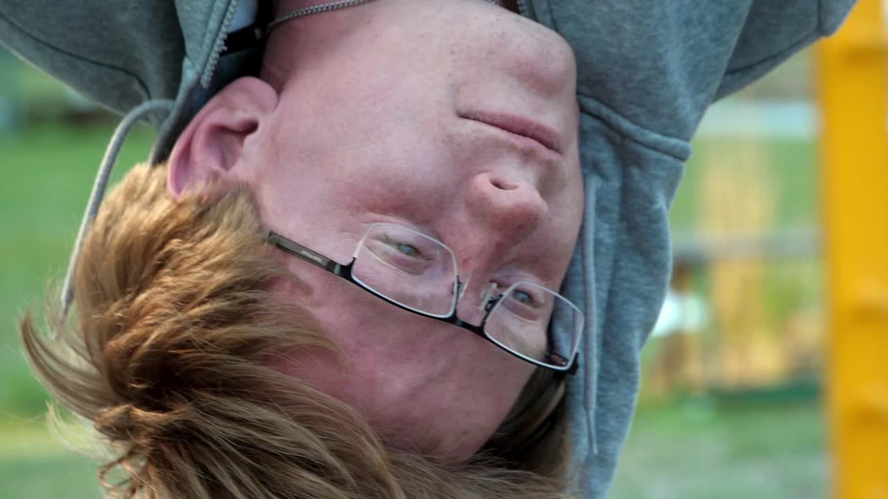 빨간 머리 백인 남자와 안경이 거꾸로 매달려 느린 동작으로 가까이