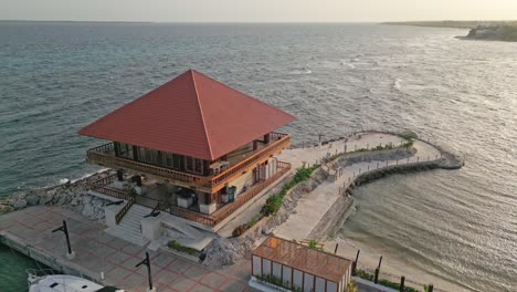 Aerial-pullback-over-marina-restaurant-on-Caribean-shore,-Captain-Kidd