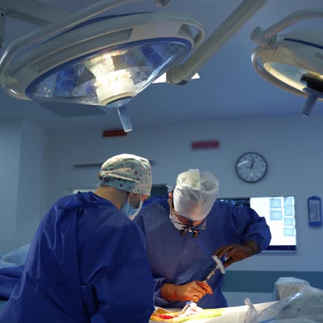 teamwork of surgeons in the operating room. surgical specialists perform an operation under bright lamps. professional doctor uses surgical tool during surgery