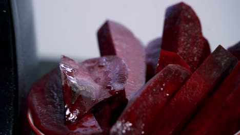 picking up a piece of beet slice from a bowl of beets to make beet pulp muffins chocolate chip vday muffins