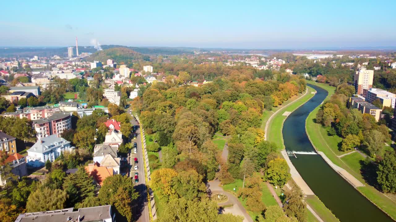 Aerial descend over autumnal trees in Komenskeho Park, Ostrava, Czech Republic, rich colors and greenery