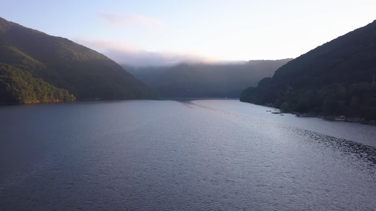 타르니타 호수, 트란실바니아, 루마니아의 반짝이는 물 표면에 일출 빛의 보라색과 분홍색 반사