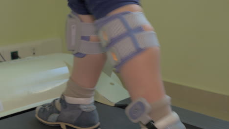 Close-up-view-of-small-boy-feet-on-treadmill-in-the-special-orthopedic-bandage-and-foot-wear