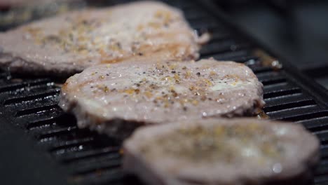 bistecs cocidos con vapor saliendo de ellos en una plancha de metal, tiro estático en cámara lenta