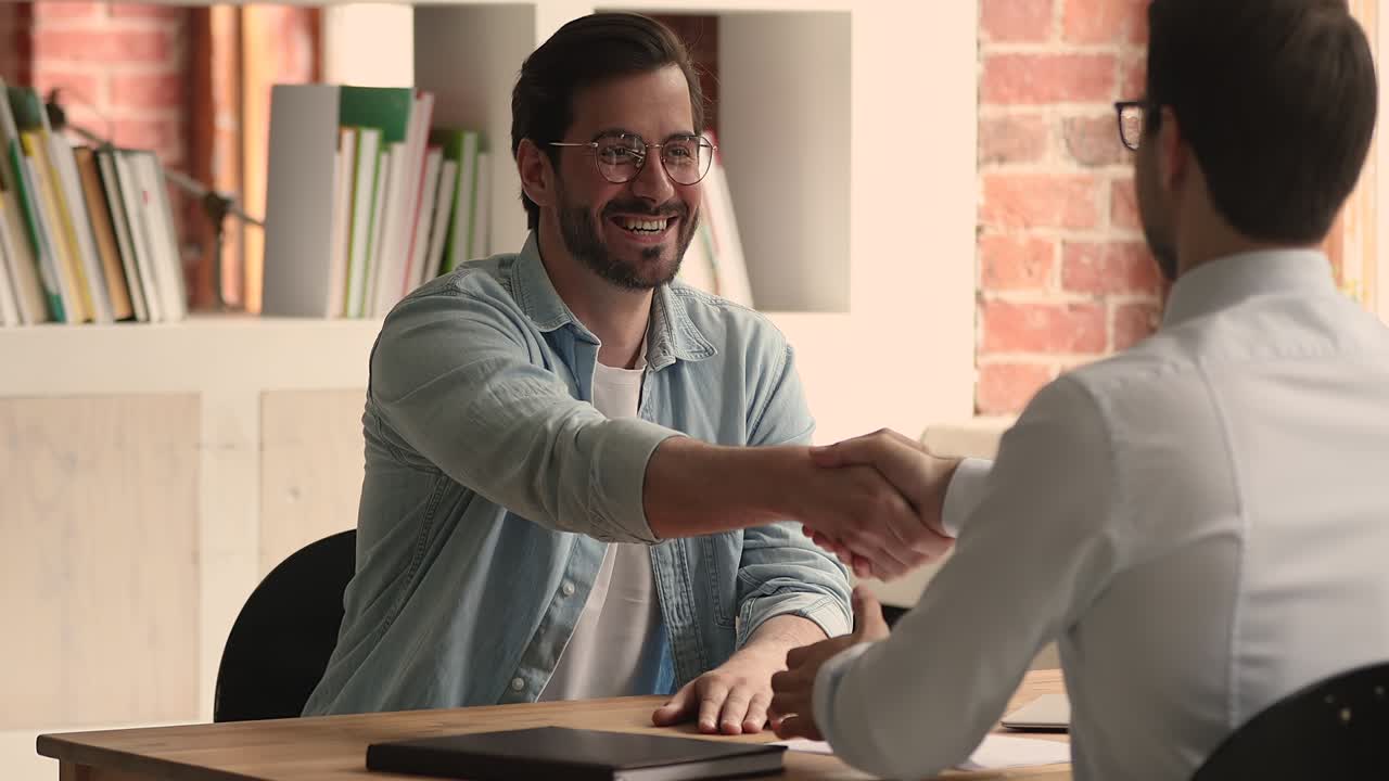 Sales manager and satisfied client shake hands closing deal