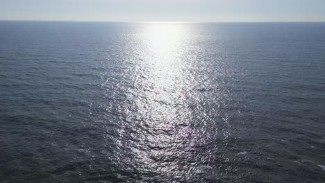 las olas besadas por el sol bailan mientras el avión no tripulado se eleva sobre el océano, capturando el brillo de la naturaleza en un viaje aéreo impresionante