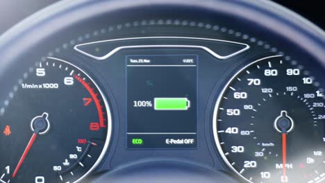 dashboard of an electric car as the battery charges at a charging station. the battery indicator fills from zero to one hundred. clip contains a battery charging graphic and battery percentage rising.
