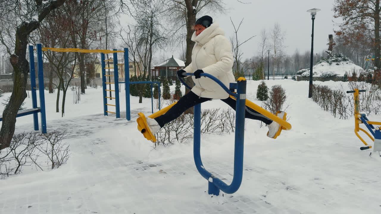 Senior Caucasian woman practicing on the simulator on the sport ground. Healthy lifestyle in winter.