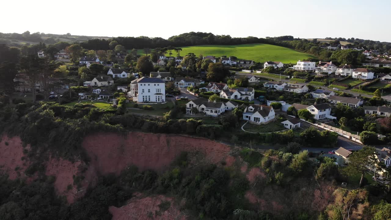 Plan panoramique vers la droite de maisons au bord de la falaise à Seaton Hole, dans le Devon, au Royaume-Uni