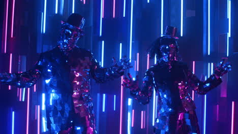 bailarines divertidos con trajes brillantes bailando en sincronía contra una pared de neón.