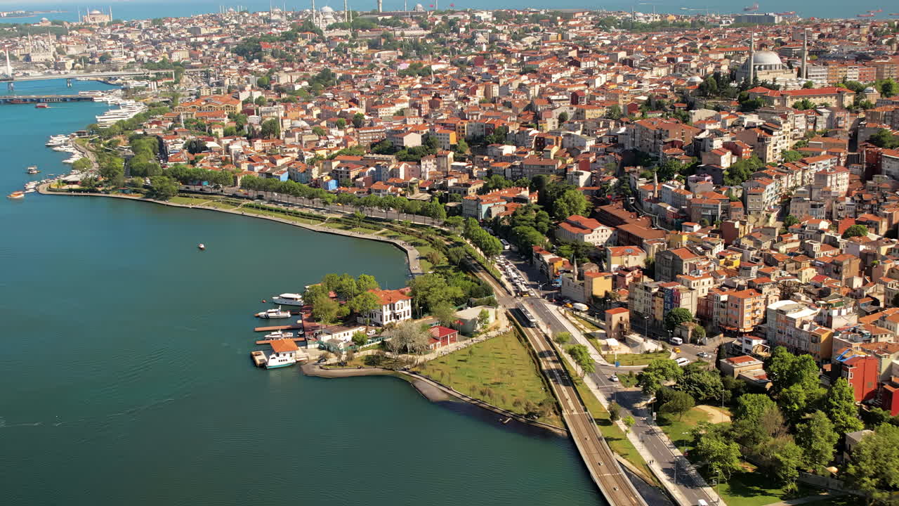 Aerial drone view of Istanbul, Turkey. Balat district with multiple residential buildings and greenery, Golden Horn waterway, downtown on the background