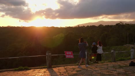 young asian female video records sun setting while hanging with girl friends, vietnam