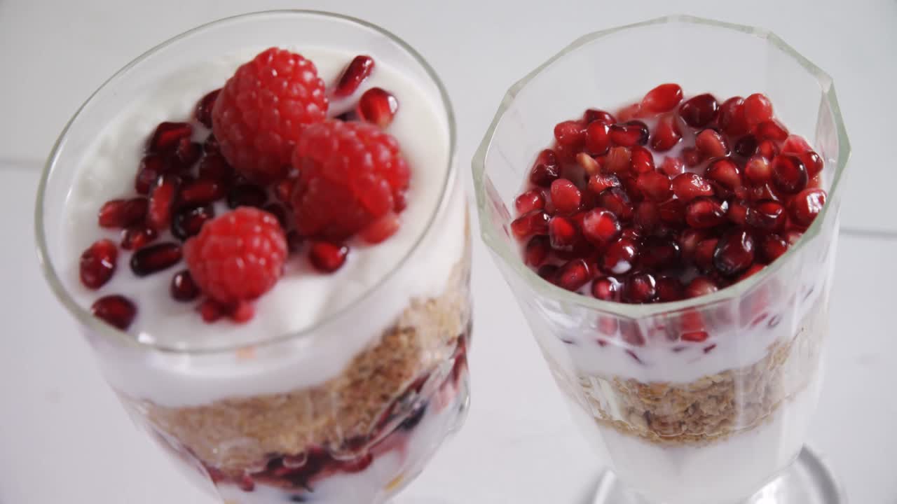 Cups of yogurt with raspberries and pomegranate seeds 4k
