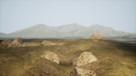 vista panorámica de un campo de hierba con montañas en el fondo