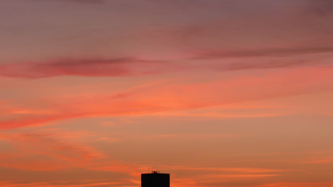 마을 물탱크 실루엣이 있는 화려한 일몰 하늘, 틸트 다운 샷