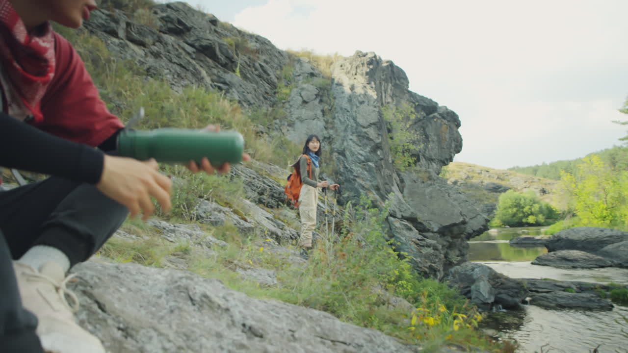 Asian Female Tourists Resting on River Bank