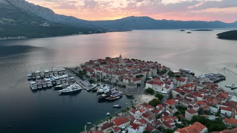 Aerial-drone-video-at-sunrise,-of-the-old-walled-town-of-Korcula-in-the-islands-of-croatia