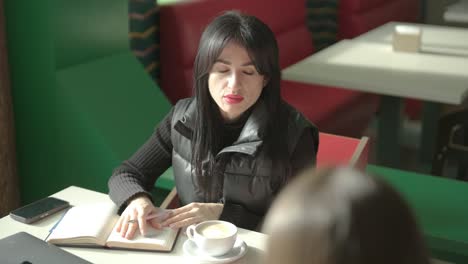 professional female manager in a black formal outfit, walking through the office, interacting with colleagues, holding documents and a laptop, showcasing leadership and professionalism